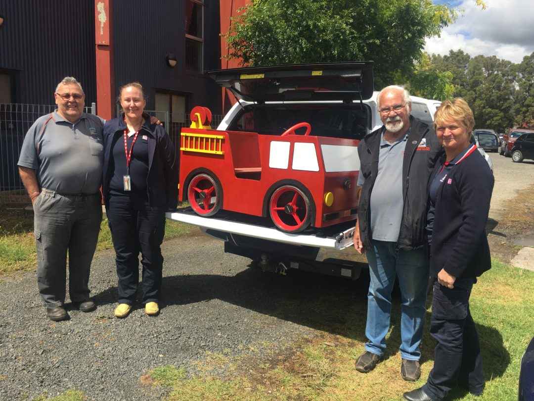 picture with some of the members with the wooden fire engine they built and worked on